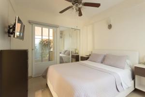 a white bedroom with a bed and a ceiling fan at Prime Location at Condado Beach 1br 1 ba - Apt 7 in San Juan