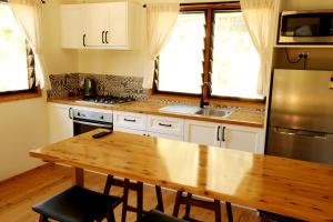 a kitchen with a wooden table and a stainless steel refrigerator at Mt Warning Rainforest Park 