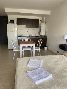 a kitchen and a table with two towels on a bed at Monoambiente zona centro in Rosario