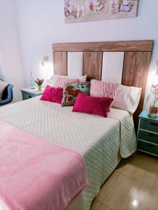 1 dormitorio con 1 cama grande con sábanas rosas y blancas en Apartamentos Hondahouse en Playa Honda Mar Menor, 1 o 2 dormitorios, en Playa Honda