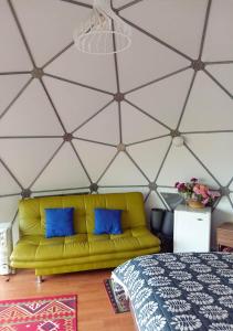 un soggiorno con divano giallo in una camera di Refugios de Alta Güita a Suesca