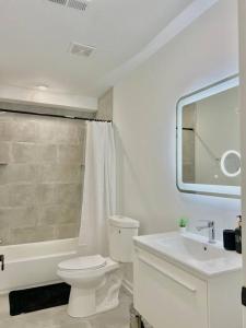 a white bathroom with a toilet and a sink at Extravagant 3 Bedroom Near art Museum in Philadelphia