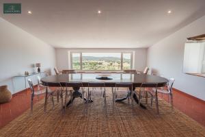 a dining room with a table and chairs and a window at Casa da Nora in Fortios