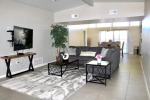 een woonkamer met een bank en een tv bij Sleek, Modern Designer home 3 in Las Cruces