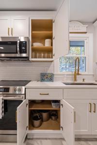 eine Küche mit weißen Schränken und einem Waschbecken in der Unterkunft Rustic 3BR Home in a Natural Cartersville Getaway in Cartersville