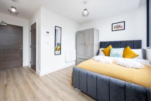 a bedroom with a large bed with yellow pillows at Bright Stylish Studio Apartment in Old Trafford in Manchester