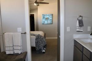 uma casa de banho com um lavatório e uma cama num quarto em Sleek, Modern Designer home 3 em Las Cruces