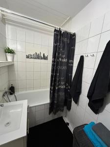 a bathroom with a black shower curtain and a sink at Park Gorzów in Gorzów Wielkopolski