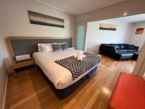 a bedroom with a large bed and a leather couch at Peppers Salt Resort & Spa 2 br luxury spa suite in Kingscliff