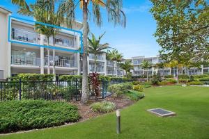 a large apartment building with palm trees and a yard at Peppers Salt Resort & Spa 2 br luxury spa suite in Kingscliff
