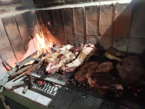 a grill with meat and other meats on it at Cañada Al Lago in Villa Parque Siquiman