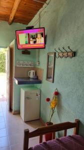 cocina con nevera y TV en la pared en Hospedaje Guandacol en Guandacol