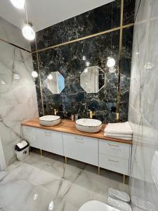 a bathroom with two sinks and two mirrors at Premium Exclusive Suite in Nowy Dwór Mazowiecki