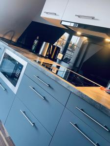 a kitchen with white cabinets and a wooden counter top at Focus Apartament in Zielona Góra