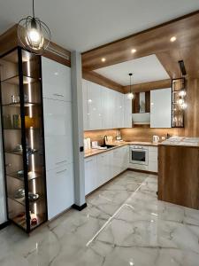 een keuken met witte kasten en een marmeren vloer bij Premium Exclusive Suite in Nowy Dwór Mazowiecki