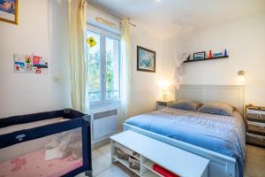 - une chambre avec un lit bleu et une fenêtre dans l'établissement Villa Calanques, à Ensuès-la-Redonne
