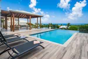 - une piscine avec des chaises longues à côté d'une maison dans l'établissement La Villa KAZ DEL MAR, à Sainte-Anne