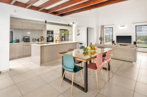 a kitchen and dining room with a table and chairs at La Villa KAZ DEL MAR in Sainte-Anne