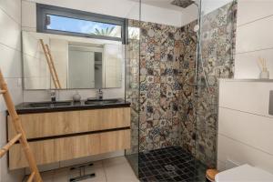 une salle de bain avec une douche avec un lavabo et un miroir dans l'établissement La Villa KAZ DEL MAR, à Sainte-Anne 14 autres photos
