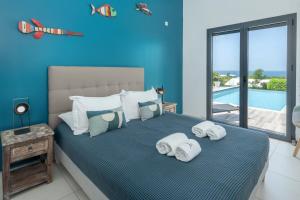 a blue bedroom with a bed with towels on it at La Villa KAZ DEL MAR in Sainte-Anne