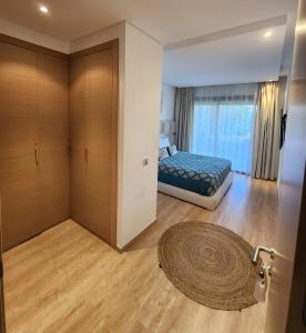 1 dormitorio con cama, armario y alfombra en Prestigia marrakech en Marrakech