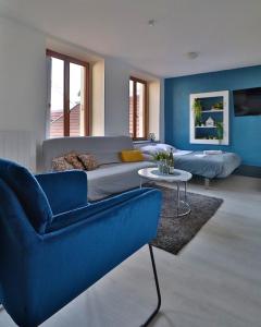 a living room with a blue couch and a table at Studio de 30m² hypercentre très calme in Montbéliard