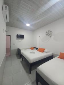Zimmer mit 2 Betten und einem TV an der Wand in der Unterkunft Hotel Oiti 