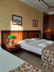 a bedroom with two beds and a green lamp on a table at GM Apartments Central Zone in Niš