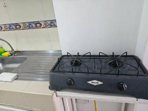 une cuisinière assise sur un comptoir à côté d'un évier dans l'établissement Apartamento acogedor confortable y céntrico para 2, à Armenia