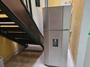 um frigorífico de metal num corredor ao lado de uma escada em Apartamento acogedor confortable y céntrico para 2 em Armênia