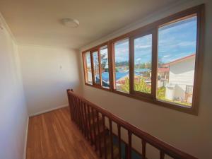 Habitación con ventanas y escalera con vistas. en Indomito Sur Hostel, en Punta Arenas