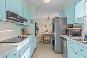 a kitchen with blue cabinets and a stainless steel refrigerator at Artsy Athens Oasis with spacious living area in Athens