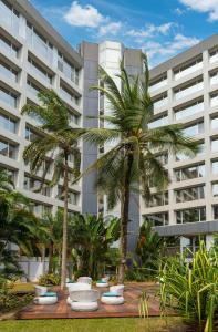自由市的住宿－利伯維爾奧古曼皇宮麗笙酒店，一座大建筑前的棕榈树