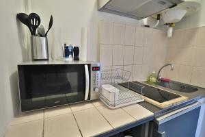 a kitchen with a microwave and a sink at Studio de 30m² hypercentre très calme in Montbéliard