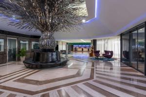 a lobby with a large tree in the middle of a building at Radisson Blu Okoume Palace Hotel, Libreville in Libreville