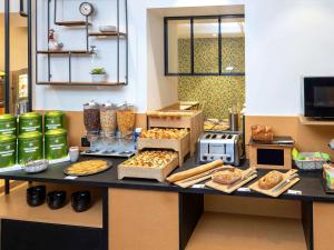 a bakery counter with various types of bread and pastries at ibis Styles Macon Centre in Mâcon