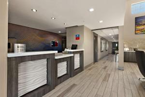 a lobby of a office building with a reception counter at SureStay Plus Hotel by Best Western Tulsa East in Tulsa
