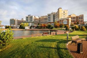 a park with benches and buildings next to a river at Radisson Residences, Zavidovo in Zavidovo