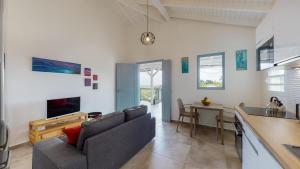 a living room with a couch and a table at Les maisons Cane in Sainte-Rose