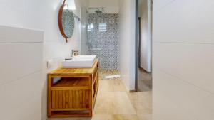 un baño con lavabo y espejo en Les maisons Cane, en Sainte-Rose 35 fotos más