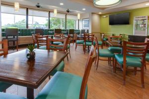 Drury Inn & Suites Nashville Airport في ناشفيل: غرفة طعام مع طاولات وكراسي خشبية