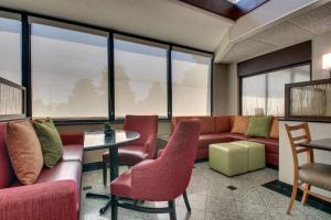 a waiting room with a couch and chairs and windows at Drury Inn & Suites Evansville East in Evansville