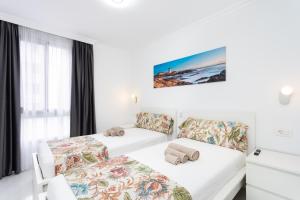 a hotel room with two beds and a window at Apartamento Clara in Los Cristianos +22 photos