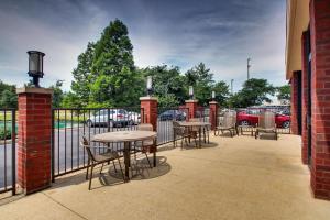 eine Terrasse mit Tischen, Stühlen und einem Zaun in der Unterkunft Drury Inn & Suites Evansville East in Evansville