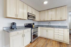 a kitchen with white cabinets and stainless steel appliances at Norris Villa 2 in La Follette