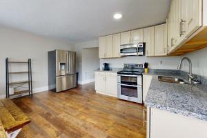 a kitchen with white cabinets and a wooden floor at Norris Villa 2 in La Follette