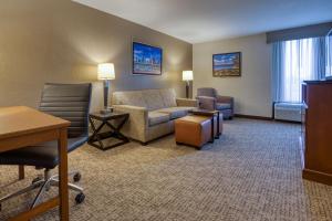 um quarto de hotel com um sofá, uma mesa e cadeiras em Drury Inn & Suites St. Louis - Fairview Heights em Fairview Heights
