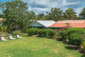 une maison avec deux chaises dans une cour dans l'établissement Hostal y Cabañas Aorangi, à Hanga Roa