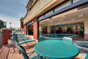 a patio with a table and chairs next to a swimming pool at Drury Inn & Suites Bowling Green in Bowling Green