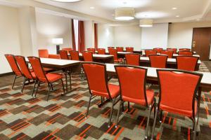 sala konferencyjna ze stołami i pomarańczowymi krzesłami w obiekcie Drury Inn & Suites St. Louis Airport w mieście Edmundson
